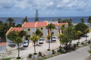 克拉伦代克Diver's Paradise Bonaire的棕榈树在海洋前的黄色房子