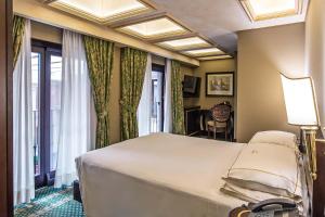 罗马河流皇宫酒店的卧室设有一张白色大床和一扇窗户。