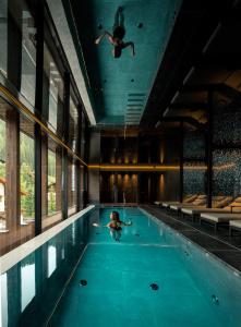 塞尔瓦迪加尔代纳山谷Linder Cycling Hotel的在室内游泳池游泳的人