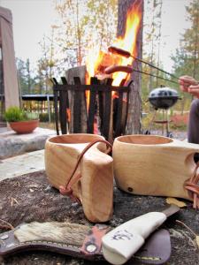 VikajärviScandinavian Dream Cottages Vikajarvi- Rovaniemi的前面有一套餐具和火