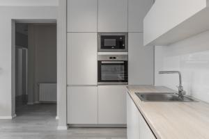 普里什蒂纳BLERI Apartment, 2 Bedroom, Free parking的白色的厨房配有水槽和微波炉