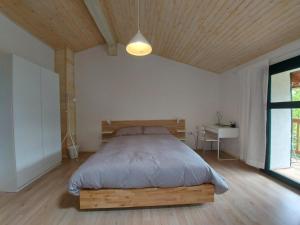 KomenApartmaji Hedera的一间卧室配有一张带木制床头板的床