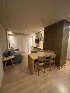 格拉玛多Gramado Resort Apart的客厅配有桌椅和沙发