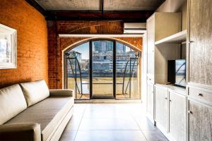 布宜诺斯艾利斯Madero Homes的带沙发和开放式窗户的客厅