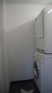杜塞尔多夫All-in-One Apartment mit eigener Sonnenterrasse im Garten的洗衣房配有洗衣机和微波炉