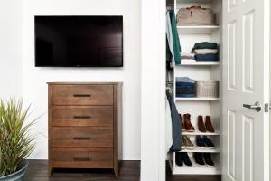 科珀斯克里斯蒂InTown Suites Extended Stay Select Corpus Christi TX的衣柜配有电视和带鞋的梳妆台