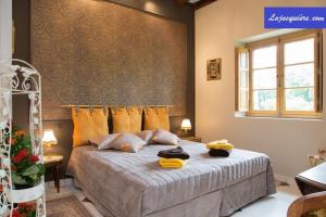 肖蒙索卢尔La Jacquière的一间卧室配有一张带黄色枕头的大床