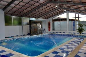 GachancipáHotel Las Palmeras Gachancipa的一座带室内游泳池的建筑中的游泳池