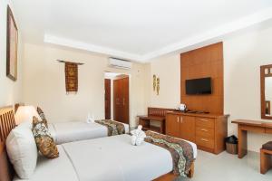 沙努尔斯里法拉别墅度假酒店的酒店客房配有两张床和一张书桌