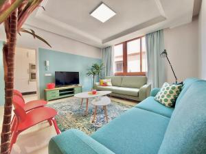 拉克鲁斯Aromas Suites Apartments的客厅配有蓝色的沙发和桌子