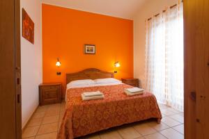 阿西西全景农家乐的一间卧室拥有橙色的墙壁,床上配有2条毛巾