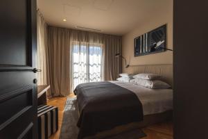 瓦比尼科DESIGN hotel VERBENICUM的一间卧室设有一张床和一个大窗户