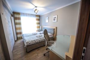 瓦多维采Aparthotel WADOWICE & Hostel GENERY的卧室配有床、椅子和窗户。