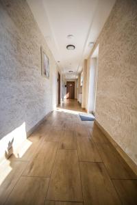 瓦多维采Aparthotel WADOWICE & Hostel GENERY的一条铺有木地板的空走廊和一面墙