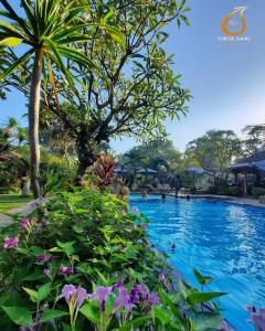 佩母德兰特塔纱丽别墅酒店的紫色花的度假胜地的游泳池