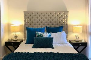 MindarieMariner's Cove ~ Luxe Waterfront Apartment的一间卧室配有一张带蓝色枕头的大床
