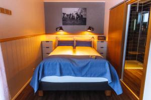 GarðurNordic Natura的小卧室配有一张带蓝色毯子的床