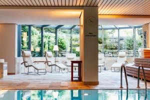 龙嫩贝格本特伯格酒店的大堂设有桌椅和游泳池