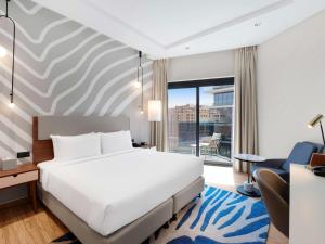 迪拜Adagio Premium The Palm的酒店客房设有一张床和一个大窗户