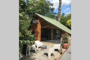 斯旺西The Shed . A cosy, peaceful, 96% recycled, chalet.的凉亭配有白色椅子和绿色屋顶