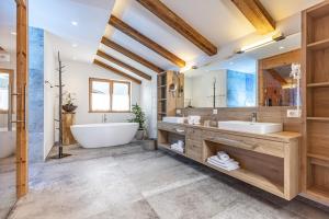 阿尔普巴赫谷地赖特Das JUWEL Reith的浴室配有大浴缸、盥洗盆和浴缸。