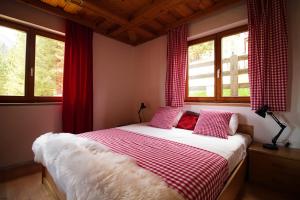 马尔尼茨Haus Waldruhe的一间卧室配有一张带红色窗帘和窗户的床。