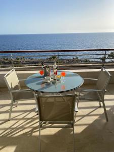 阿吉内金海滩Anfi del Mar的阳台配有桌椅