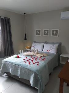 邦比尼亚斯Pérola de Bombinhas的一间卧室,床上有红色玫瑰