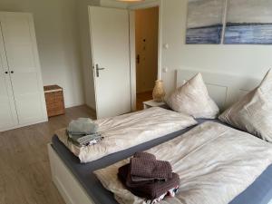 威克奥夫弗尔Wohnen am Südstrand - Ferienwohnung 1 6的一间卧室配有两张带毛巾的床