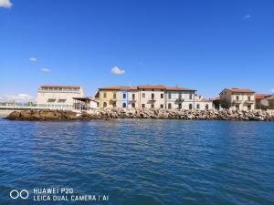 马里纳·迪·比萨bilocale Marina di Pisa的水体岸边的一群房子