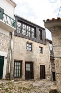 FolgosinhoCasa dos Limos Verdes的一座带窗户和阳台的古老石头建筑