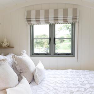 CorsleyWhitbourne farm的卧室配有带白色枕头的床和窗户。