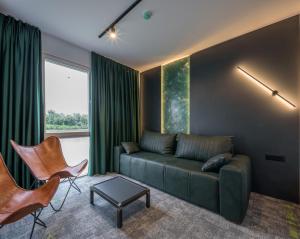 贝尔格莱德Joy 5 Hotel & SPA的客厅配有绿色沙发和椅子