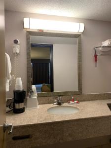 哈里森堡Days Inn by Wyndham Harrisonburg的浴室的柜台设有水槽和镜子