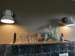 阿姆斯特丹Appartement Voorhuis en chalet Klein Waterland的墙上装有玻璃瓶和碗的架子