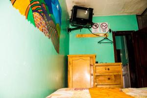 拉塔昆加La Posada Del Viajero的卧室配有一张床,墙上配有电视。