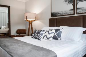 CaçadorHotel Kindermann的一间卧室配有带白色床单和枕头的床。