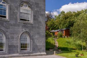 Tower BridgeHawthorn Hut Kilkenny Glamping at Jenkinstown House的一座石头建筑,有院子和房子