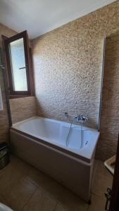 罗查基恩爱琴海海浪-灯塔酒店的浴室配有浴缸及镜子