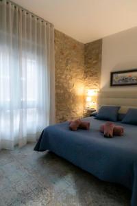 德尼亚Casa Estrella y Casa Carmen的一间卧室设有蓝色的床和石墙