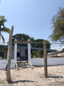普拉亚布兰卡Casa Greca的沙滩上的一座建筑,在沙滩上有两个原木