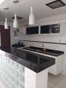 卡波布里奥Casa Estelar的厨房配有黑色台面和吊灯