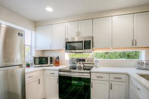 北湾Moon River Suites #4的厨房配有白色橱柜和炉灶烤箱。
