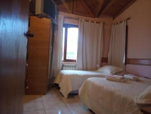 乌斯怀亚Departamentos Paisaje del Beagle的一间卧室设有两张床和窗户。