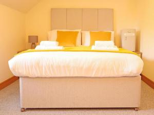 威廉堡Highland Stays - Rushfield House Rooms的一间卧室配有一张带黄色枕头的大床