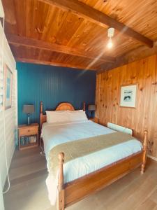 Glenaire格雷纳尔小屋乡村民宿的一间卧室设有一张木天花板床。