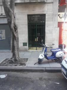 布宜诺斯艾利斯TANGO GUAPO APART的停在树旁的一辆蓝白摩托车