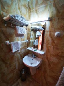 坎撒林Resort Palmeiras Dourado的浴室配有盥洗盆、镜子和毛巾