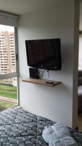 波哥大Apartaestudio Sector Hayuelos的卧室的墙上设有平面电视