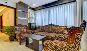 维沙卡帕特南Treebo Trend Siesta Muralinagar的客厅配有沙发、椅子和桌子